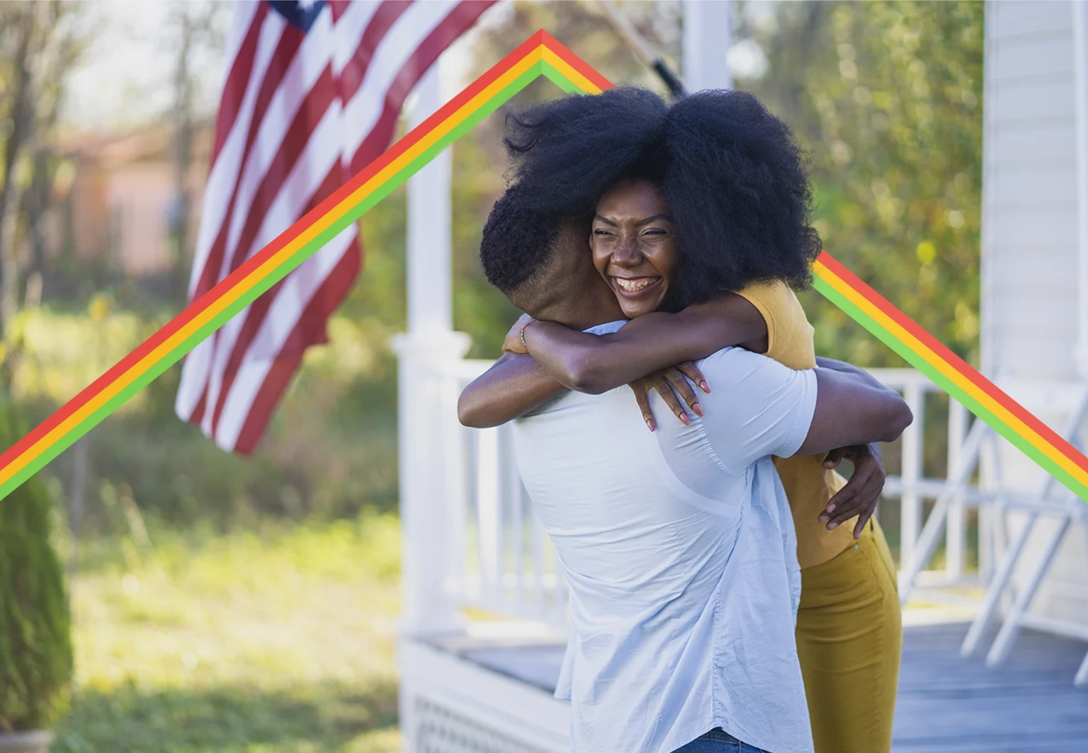 Black couple hugging each other in front of their porch.